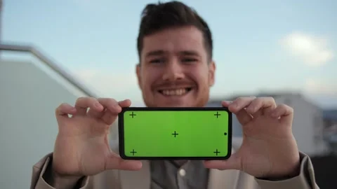 Smartphone horizontal orientation with a green screen and tracking dot. Man stay Stock Footage 240691682