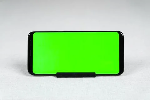 A smartphone in a horizontal position with a green screen Stock Photos