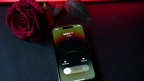 Smartphone incoming call from mom with heart icon beside red rose, neon light Stock Footage 328529751