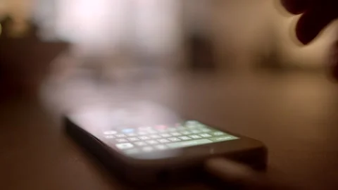 Smartphone interaction often occurs in low light, highlighting the need for touc Stock Footage 295932562