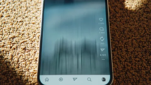 Smartphone lying on couch, social media feed scrolling on screen in time-lapse Stock Footage 328199378
