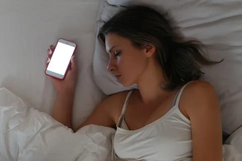 Smartphone is lying in womans hand while she sleeping Stock Photos