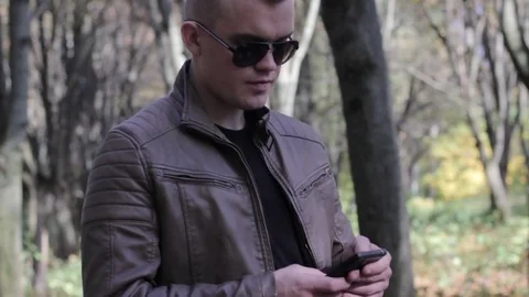 Smartphone man sms texting using app on smart phone outdoors in summer. Handsome Stock Footage 81370580