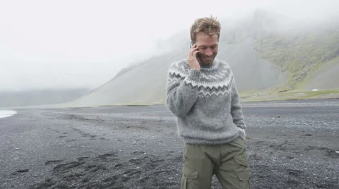 Smartphone man talking on mobile smart phone in Icelandic sweater on Iceland Stock Footage 46128090