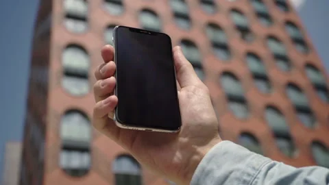 Smartphone in a man's hand. The use of technology in an urban environment  Stock Footage 133947532
