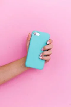 Smartphone in a mint case on a pink background. Stock Photos