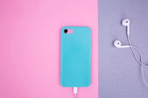 Smartphone in a mint case on a pink background. Stock Photos