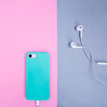 Smartphone in a mint case on a pink background. Stock Photos