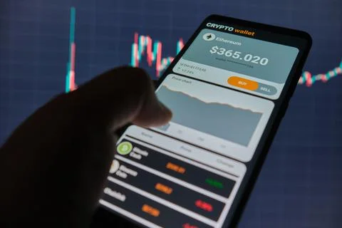 Smartphone with mobile application cryptocurrency wallet. A man analyzes the  Stock Photos