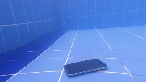 Smartphone, mobile phone falls into the pool. Underwater view angle shooting. Stock Footage 172090738