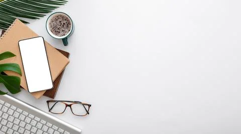Smartphone mock up screen note keyboard glasses palm leaves on white work space Stock Photos
