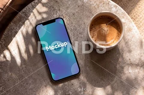 Smartphone mockup with a coffee mug PSD Template