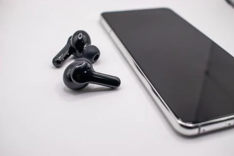 Smartphone next to the earphone. Stock Photos