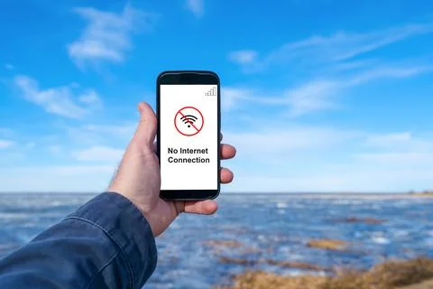 Smartphone with no internet connection message outdoors by water. No intern.. Photos