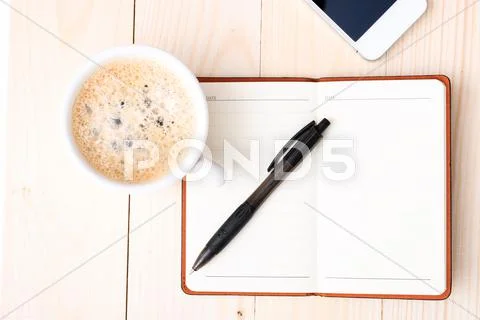 Smartphone with notebook and cup of strong coffee Stock Photos