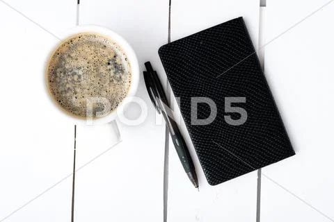 Smartphone with notebook and cup of strong coffee Stock Photos