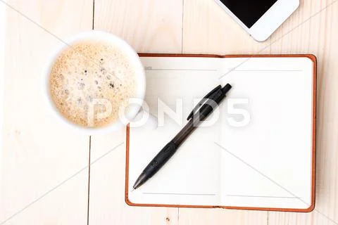 Smartphone with notebook and cup of strong coffee Stock Photos
