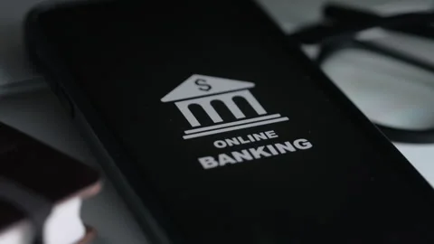Smartphone with online banking image on white table near notebook and glasses Stock Footage 268985992