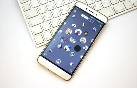 Smartphone open apps Nimses application on laptop keyboard. Stock Photos