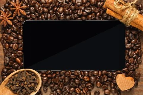 Smartphone or tablet with frame of coffee beans and condiments Stock Photos