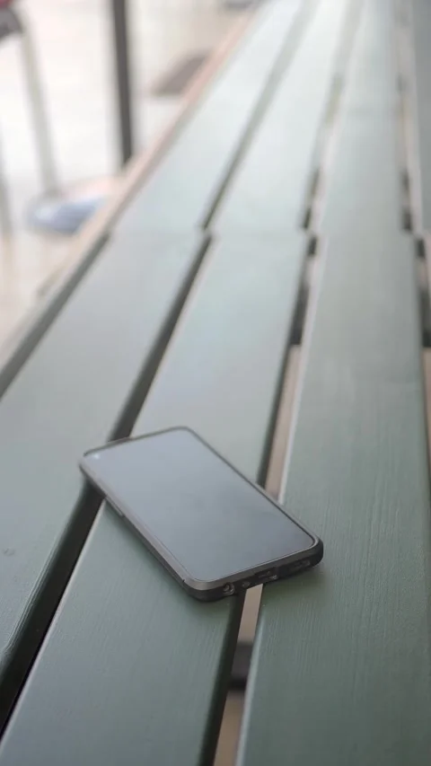Smartphone on a park bench. lost smart phone concept Stock Footage 337809179