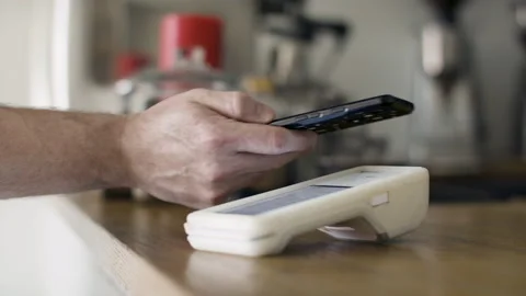 Smartphone payment with tap wireless system in a small shop. Stock Footage