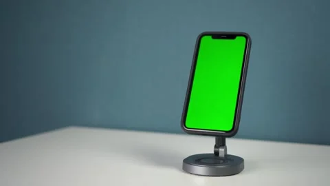 Smartphone placed on magnetic station with wireless charging. Phone with green Video stock 314465309