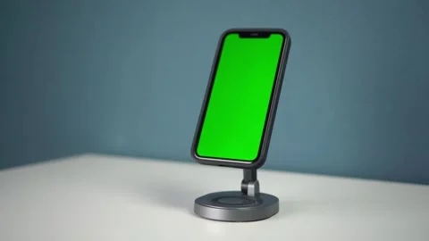 Smartphone placed on magnetic station with wireless charging. Phone with green Stock Footage 314465391