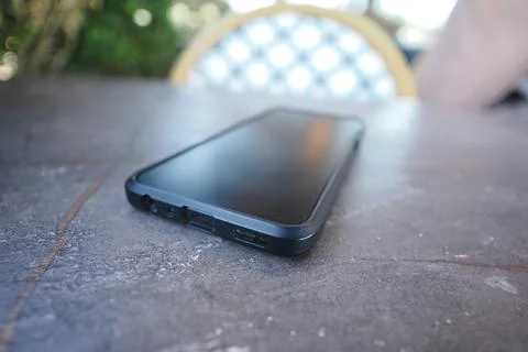 Smartphone placed on a table in an outdoor setting. lost smart phone concept Stock Photos