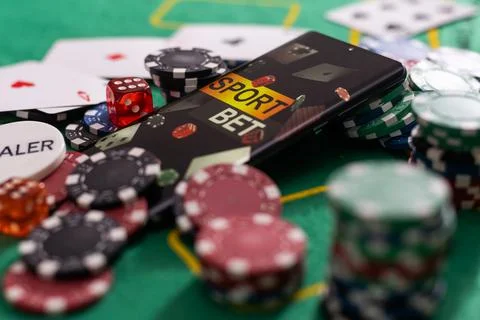 Smartphone with poket table on screen, playing cards and chip cards on poker 库存照片