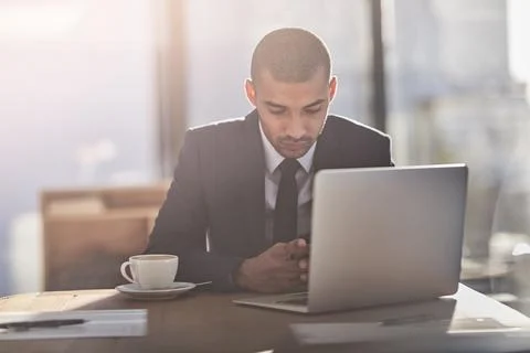 The smartphone is a powerful business tool. a young businessman using his Stock Photos