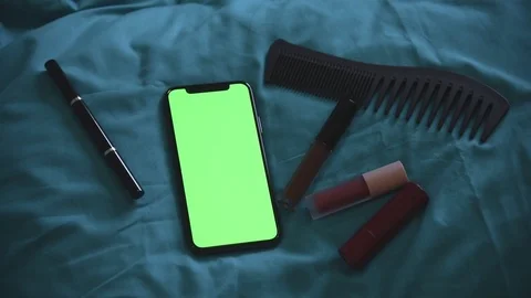 Smartphone put down on blue pillow with cosmetic for woman female Stock Footage 122360845