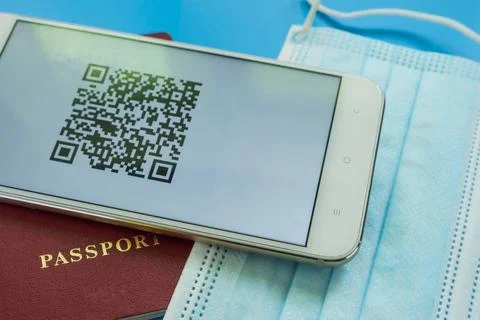 A smartphone with a QR code about the Covid-19 vaccination lies on the passpo Stockfoto's