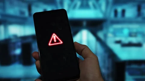 A smartphone with a red triangle warning icon is displayed Stock Footage 340509903
