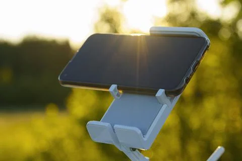 Smartphone remote control in mount on sunlight background Foto stock