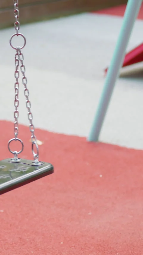 Smartphone resting on a playground swing with chains, surrounded by colorful Vidéo 341439323