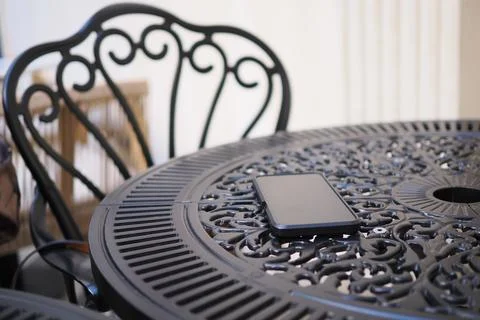 Smartphone resting on a round table at a cafe. lost smart phone concept Stock Photos