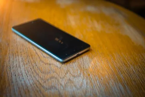 A smartphone rests on a table in a cafe Stock-Fotos