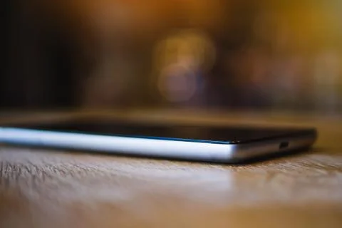 A smartphone rests on a table in a cafe Foto stock