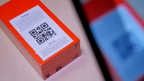 Smartphone scanning QR code in paper label on the orange package or parcel box Video stock 96487670