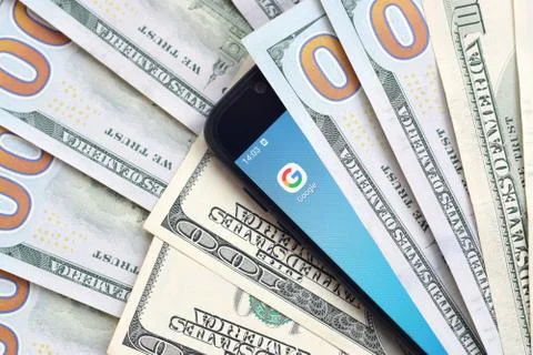Smartphone screen with Google app and lot of hundred dollar bills. Business a Foto stock