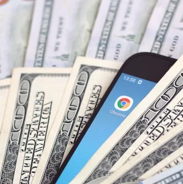 Smartphone screen with Google chrome app and lot of hundred dollar bills. Bus Foto stock