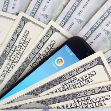 Smartphone screen with Google chrome app and lot of hundred dollar bills. Bus Foto stock
