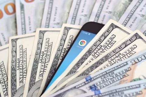 Smartphone screen with Google chrome app and lot of hundred dollar bills. Bus Foto stock