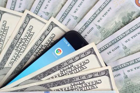Smartphone screen with Google chrome app and lot of hundred dollar bills. Bus Foto stock