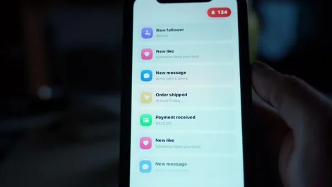 Smartphone screen with notification list and red counter badge in dark room. Stock-Footage 342912274