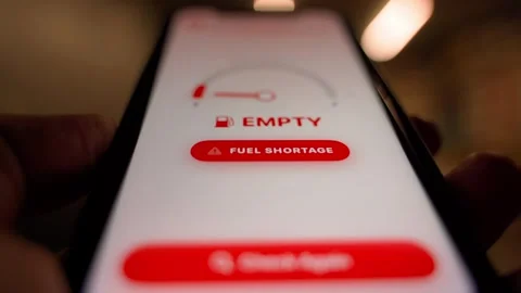 Smartphone screen showing empty fuel gauge with fuel shortage warning close-up 스톡 동영상 341746616