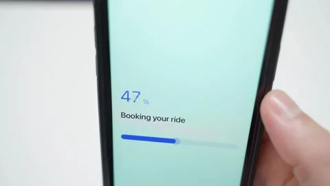 Smartphone screen showing ride booking progress and confirmation that driver is Stock Footage 342130282