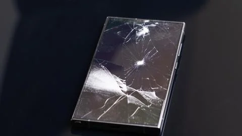 Smartphone shattered screen. The screen of a modern smartphone is shattered.. Stock Photos