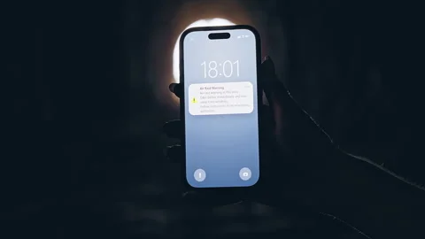Smartphone Showing Air Raid Warning Notification in Dark Tunnel With Bright Ligh Stock Footage 335223003